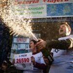 Dos loteros celebran que el décimo premiado con "el Gordo" de la Lotería de Navidad de 2019 se vendió en en su establecimiento.