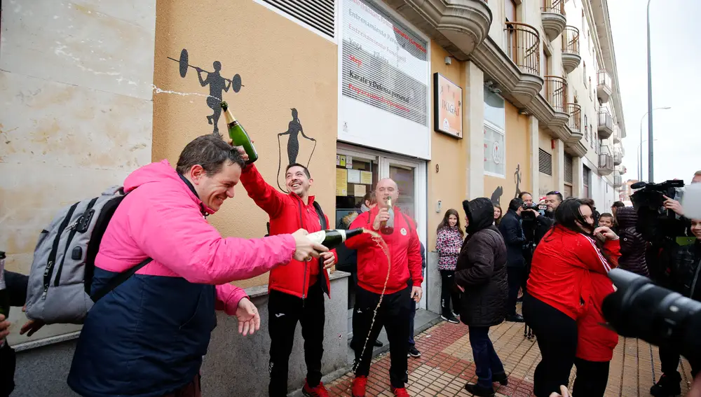 Un grupo de amigos celebran que han ganado "El Gordo de la Lotería", frente al gimnasio Seiza 2 donde se repartió el número 26.590, premiado con el Primer Premio de la Lotería de Navidad, en Salamanca