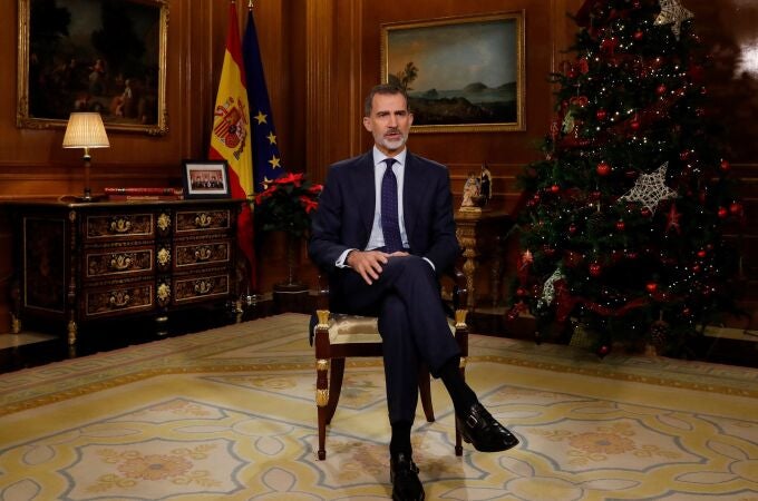 El Rey pronuncia su mensaje junto a una foto con representantes de la sociedad española y las banderas de España y la UE
