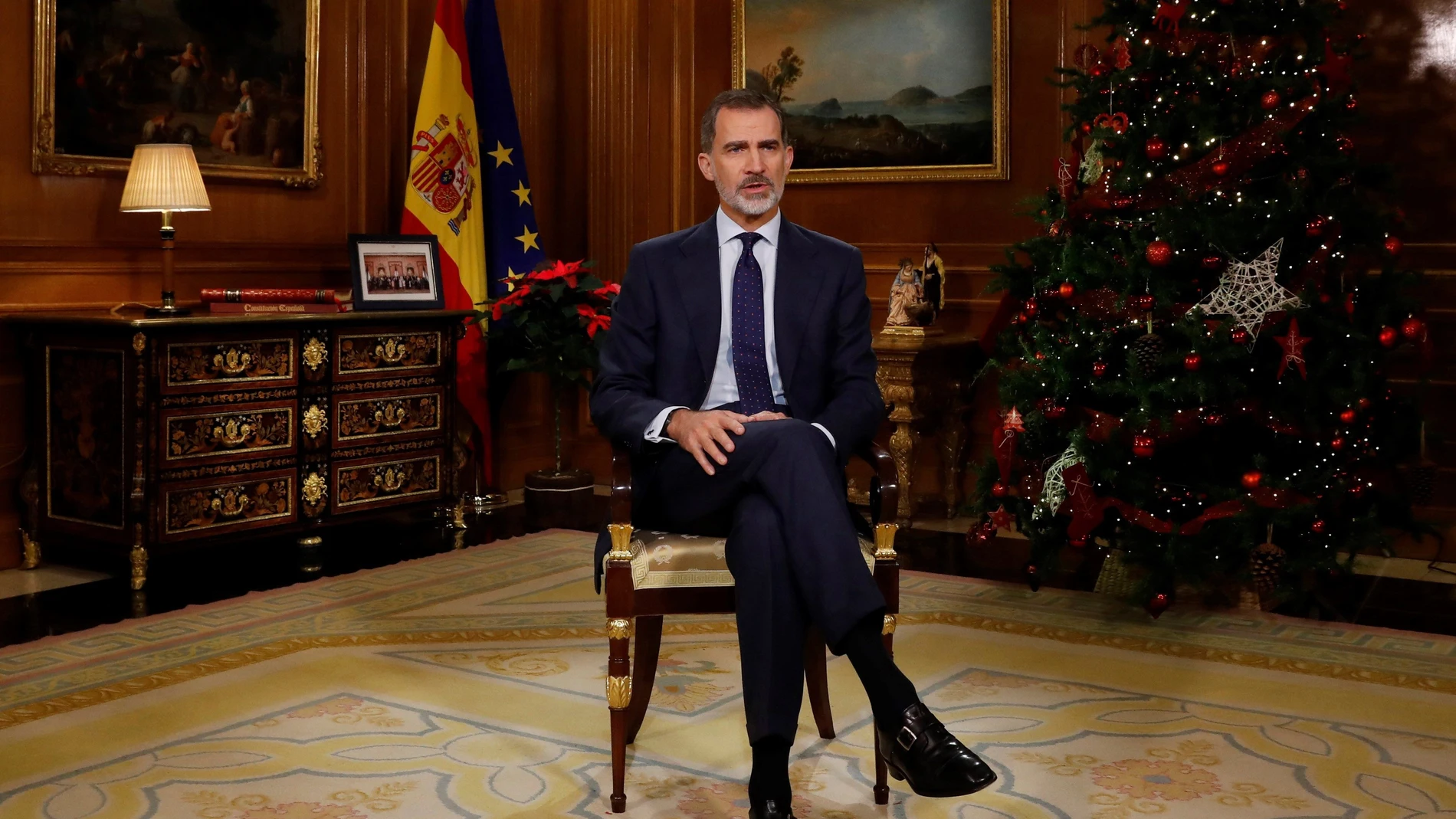 El Rey pronuncia su mensaje junto a una foto con representantes de la sociedad española y las banderas de España y la UE