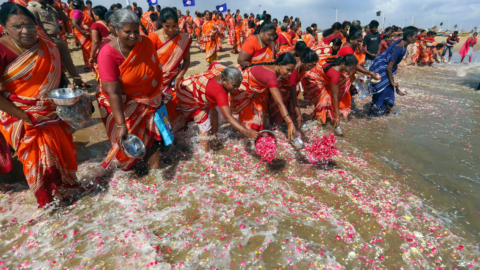 Un grupo de mujeres arroja flores en la costa en recuerdo de las víctimas del tsunami de 2004