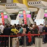 Varios viajeros esperan para facturar en un mostrador del aeropuerto Adolfo Suárez Madrid-Barajas en Madrid