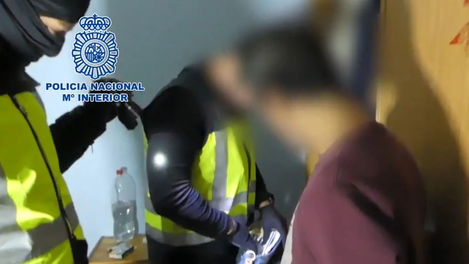 GRAF4935. MADRID, 28/12/2019.- Fotografía facilitada por la Policía Nacional que muestra a uno de los detenidos mientras miembros de la policía registran ciertos documentos durante una operación contra siete presuntos atracadores que en menos de dos meses habrían cometido catorce robos en establecimientos comerciales de Madrid y Guadalajara a cuyos empleados amenazaban con hachas, armas blancas o armas de fuego. EFE/ - **SÓLO USO EDITORIAL/ NO VENTAS**