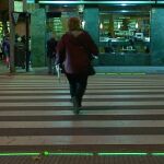 Una salmantina pasa por un cruce iluminado para indicar al peatón despistado con el móvil si debe cruzar o no