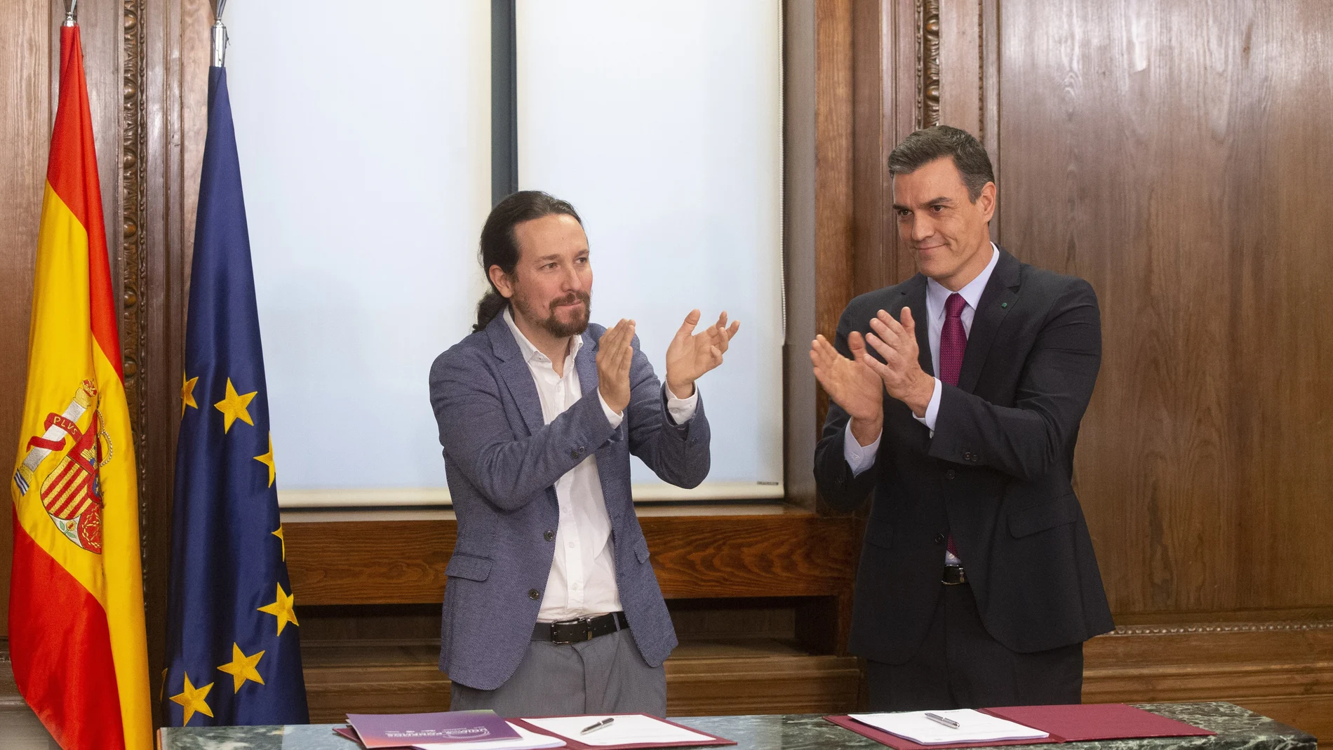 Pablo Iglesias y Pedro Sánchez se aplauden tras firmar el pacto