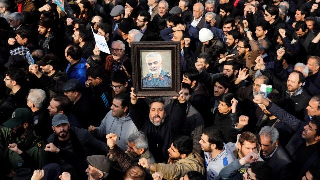Un manifestante alza un retrato del difunto comandante de la Fuerza Quds de los Guardianes de la Revolución de Irán, Qasem Soleimaní, durante una protesta multitudinaria contra EEUU, este viernes en Teherán (Irán). EFE/Abedin Taherkenareh