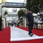 Crew worker Carlos Romero kicks out red carpet protection during the 77th Annual Golden Globe Awards Preview Day at the Beverly Hilton, Friday, Jan. 3, 2020, in Beverly Hills, Calif. The annual awards show recognizing excellence in film and television will be held on Sunday. (AP Photo/Chris Pizzello)