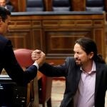 El líder de Unidas Podemos, Pablo Iglesias, saluda a Pedro Sánchez