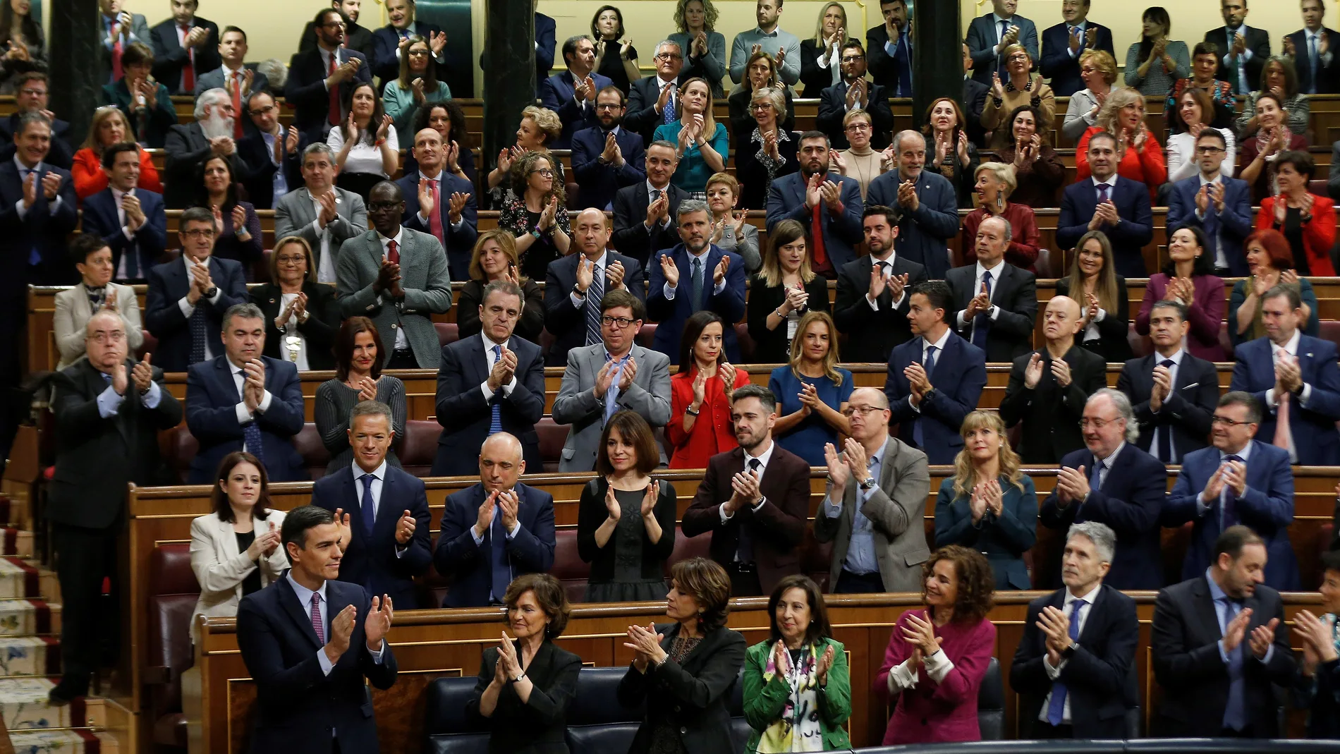 El candidato a la Presidencia del Gobierno, Pedro Sánchez (i), recibe el aplauso de sus compañeros de partido tras finalizar su discurso en el Congreso de los Diputados durante la primera jornada de la sesión de su investidura como presidente del Gobierno.