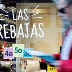 Un hombre pasa ante el escaparate de una tienda que ofrece descuentos de hasta el 50 por ciento, en una imagen de archivo