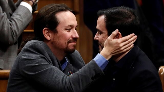 El líder de Unidas Podemos, Pablo Iglesias (i), se abraza con el líder de Izquierda Unida, Alberto Garzón, después de que el candidato socialista Pedro Sánchez lograra este martes la confianza del Congreso para un nuevo mandato como presidente del Gobierno, al lograr una estrecha mayoría de 167 votos a favor, 165 en contra y 18 abstenciones. EFE/ Mariscal