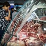 ACOMPAÑA CRÓNICA***AME1624. BUENOS AIRES (ARGENTINA), 13/01/2020.- Una mujer mira este lunes una vitrina de una carnicería en la ciudad de Buenos Aires (Argentina). El consumo de carne vacuna en Argentina, uno de los países con mayor tradición "carnívora", ha caído al nivel más bajo en una década, consecuencia no solo del avance de los consumidores 'veggies', sino principalmente por la pérdida del poder adquisitivo por la crisis económica que vive el país desde 2018. El tradicional asado de los domingos se transformó en una versión más magra y económica, en el que la carne vacuna ya no tiene la exclusividad y comparte parrilla con el pollo y el cerdo y, por qué no, también con verduras asadas. EFE/Juan Ignacio Roncoroni
