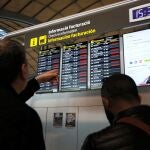 Dos viajeros miran un panel tras el cierre por precaución a causa de la borrasca Gloria del aeropuerto de Alicante-Elche que afectará a un total de 190 vuelos programados.