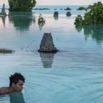 Un niño de 16 años nada en la zona inundada en Kiribati.