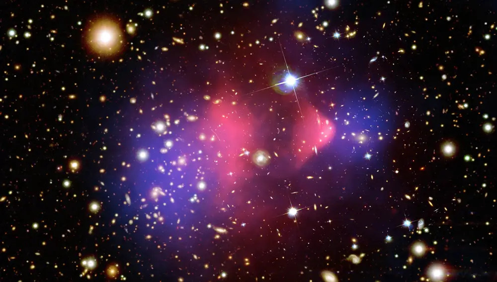 El Cúmulo de la Bala, en la constelación de Carina, es un grupo de unas 40 galaxias formado por dos grupos más pequeños que colisionaron entre sí hace más de 150 millones de años. En él podemos localizar la materia oscura observando dónde es más intensa la gravedad. Si lo hacemos, descubrimos que la gravedad se concentra en dos burbujas (las zonas azules) que corresponden con los dos grupos iniciales. En esas burbujas están todas las galaxias del cúmulo, junto con la mayoría de la materia oscura.