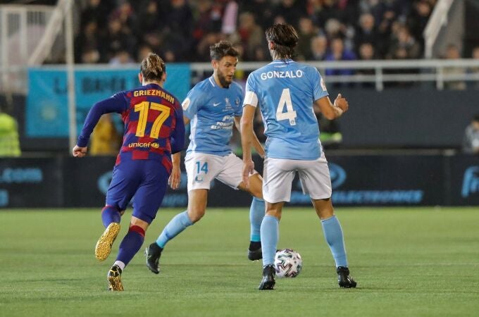 El centrocampista del Ibiza Miguel Núñez (c) controla el balón ante el delantero francés del Barcelona Antoine Griezmann (i) durante el partido de dieciseisavos de final de la Copa del Rey que se disputa este miércoles en el estadio de Can Misses. EFE/ Sergio G. Canizares