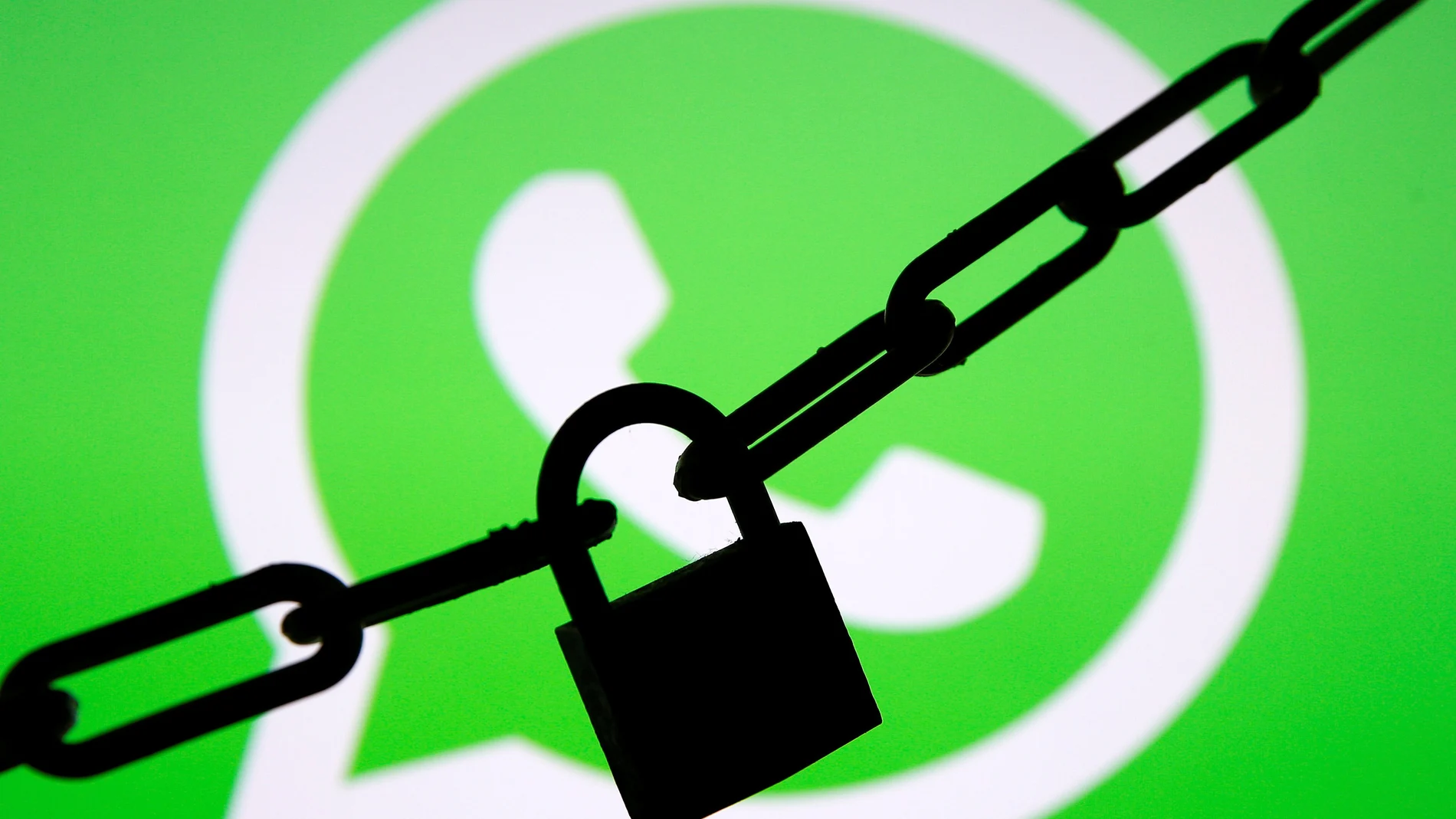 FILE PHOTO: A photo illustration shows a chain and a padlock in front of a displayed Whatsapp logo