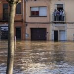 People stand at a balcony during flooding following a storm in Girona, Spain, on Thursday, Jan. 23, 2020. At least 11 have died and five people remained missing on Thursday following a calamitous storm that has caused rivers to overflow and sea waters to inundate vast agricultural areas in eastern Spain. (AP Photo/Emilio Morenatti)
