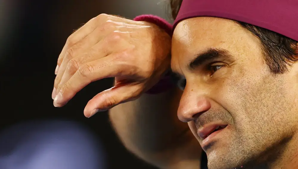 Federer se seca el sudor durante su partido contra Millman