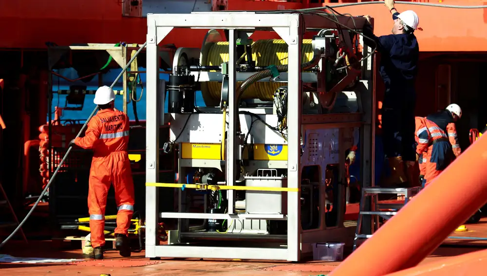 Varias personas trabajan en la instalación de un sonar y de un robot submarino en sendos barcos de Salvamento Marítimo, desplegados para estos trabajos y con los que se comenzará la búsqueda submarina del pesquero desaparecido