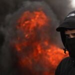 Un manifestante palestino con el rostro cubierto, este jueves, durante las protestas contra el "Acuerdo del Siglo" anunciado por el presidente estadounidense Donald Trump