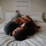 Dos personas se abrazan cariñosamente en una cama