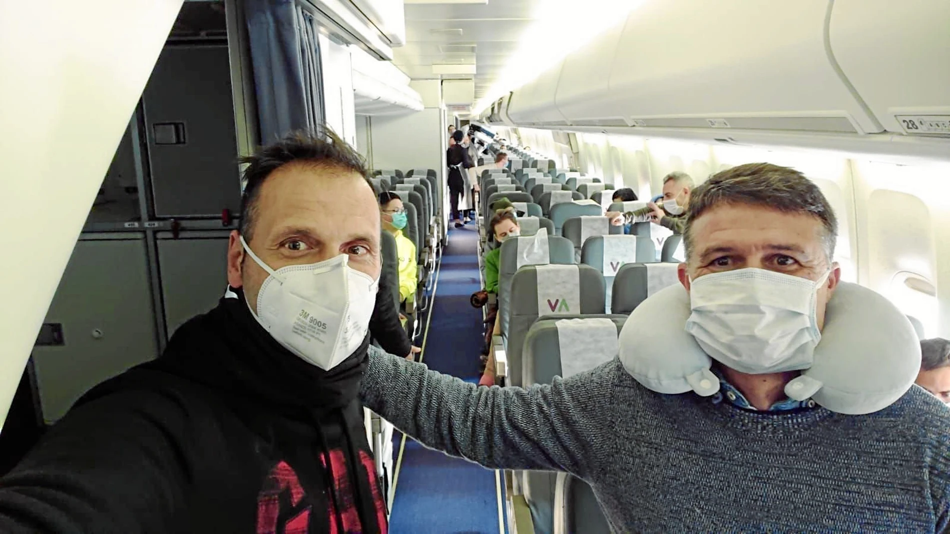 El entrenador de fútbol, Oliver Cuadrado, junto a un compañero en el avión de Wuhan