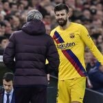Barcelona's head coach Quique Setien, left, speaks with Barcelona's Gerard Pique as he is substituted during the Spanish Copa del Rey, quarter final, soccer match between Athletic Bilbao and Barcelona at San Mames stadium in Bilbao, Spain, Thursday, Feb. 6, 2020. (AP Photo/Alvaro Barrientos)