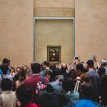 Varios visitantes se sacan selfies junto con la Mona Lisa