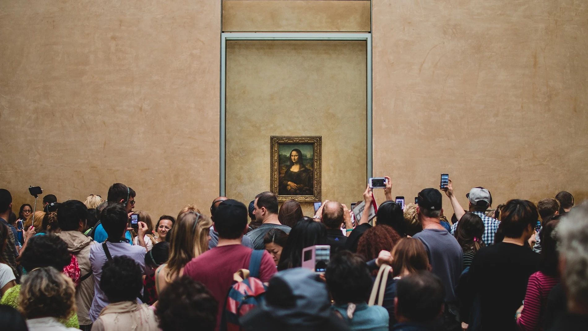 Varios visitantes se sacan selfies junto con la Mona Lisa