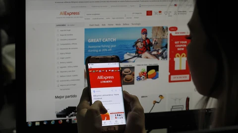 Mujer agarrando su dispositivo móvil con ambas manos y deslizando con un solo pulgar