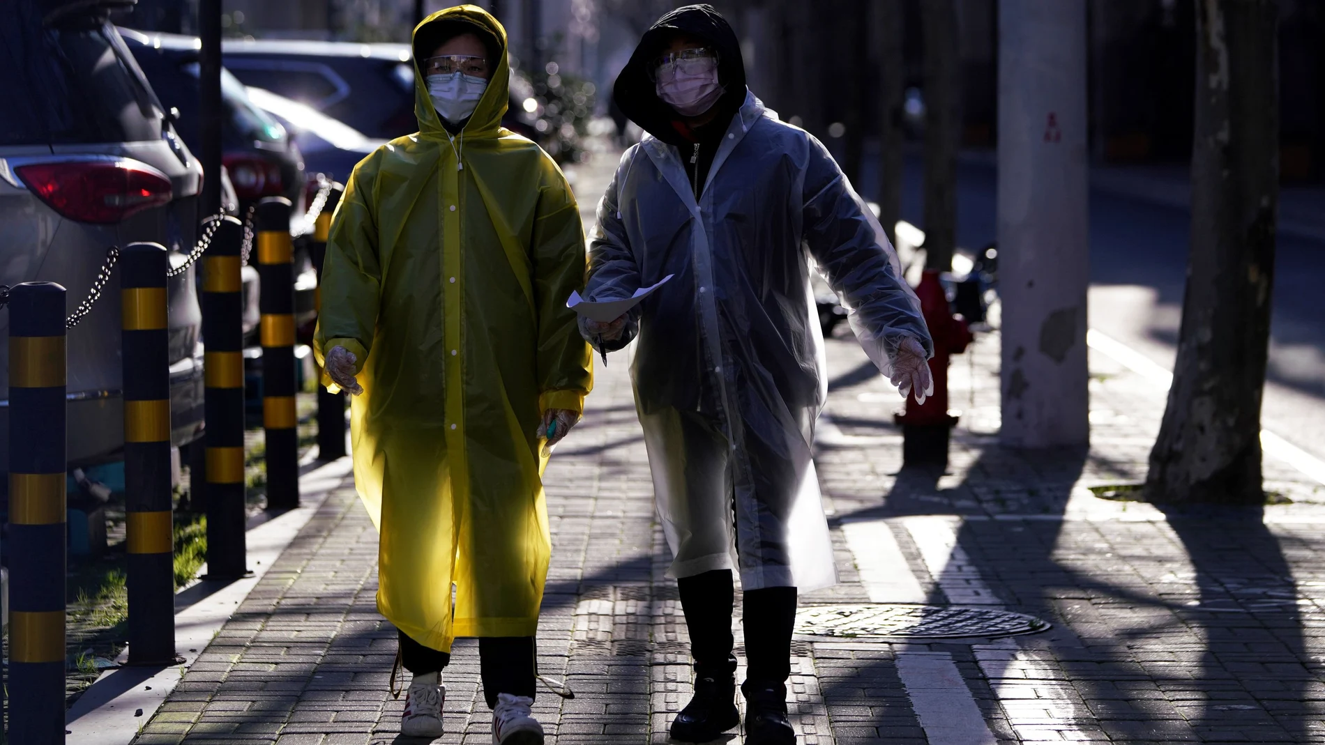 Women wear face masks and plastic raincoats as a protection from coronavirus in Shanghai