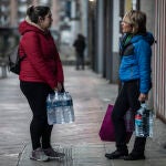 Mujeres comprando agua potable por consejo de las autoridades para evitar el consumo de agua potable.