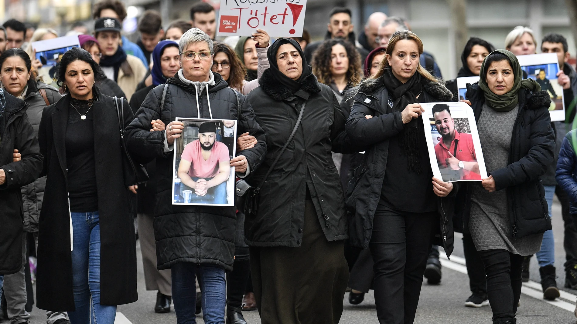 Amigos y familiares sostienen fotos de las víctimas de un tiroteo, en Hanau, Alemania, el viernes 21 de febrero de 2020. (Foto AP / Martin Meissner)