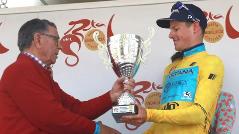 El ciclista danés Jakob Fuglsang (d) del equipo Astana, recibe del ex ciclista Joaquim Galera el trofeo de líder absoluto de la Vuelta a Andalucía. EFE Pepe Torres