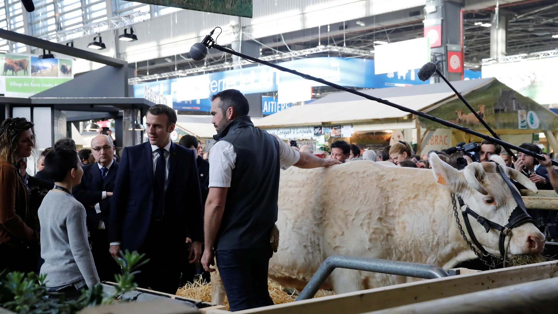 French President Emmanuel Macron speaks with a farmer during a visit to the 57th International Agriculture Fair (Salon international de l'Agriculture) at the Porte de Versailles exhibition center in Paris