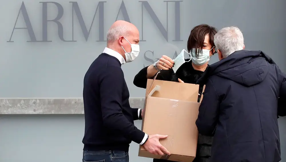 A worker holds a face mask outside the theatre where the Italian designer Giorgio Armani said his Milan Fashion Week show would take place to safeguard the health of press and buyers after a coronavirus outbreak in northern Italy, in Milan, Italy, February 23, 2020. REUTERS/Alessandro Garofalo
