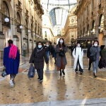 Turistas asiáticos pasean con mascarillas por la comercial Galleria Vittorio Emanuele de Milán