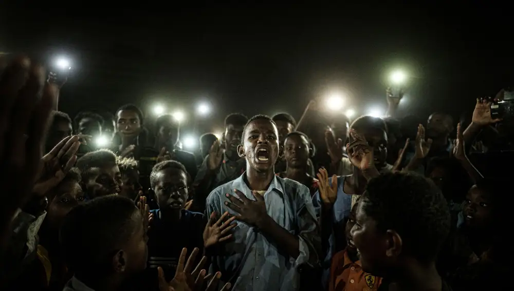 Picture nominated for World Press Photo of the Year shows: A young man, illuminated by mobile phones, reciting a poem while protestors chant slogans calling for civilian rule, during a blackout in Khartoum, Sudan, June 19, 2019. Yasuyoshi Chiba for Agence France-Presse/World Press Photo Handout via REUTERS THIS IMAGE HAS BEEN SUPPLIED BY A THIRD PARTY. NO RESALES. NO ARCHIVES. THE IMAGE CAN NOT BE USED FOR PUBLICATION COVERS.