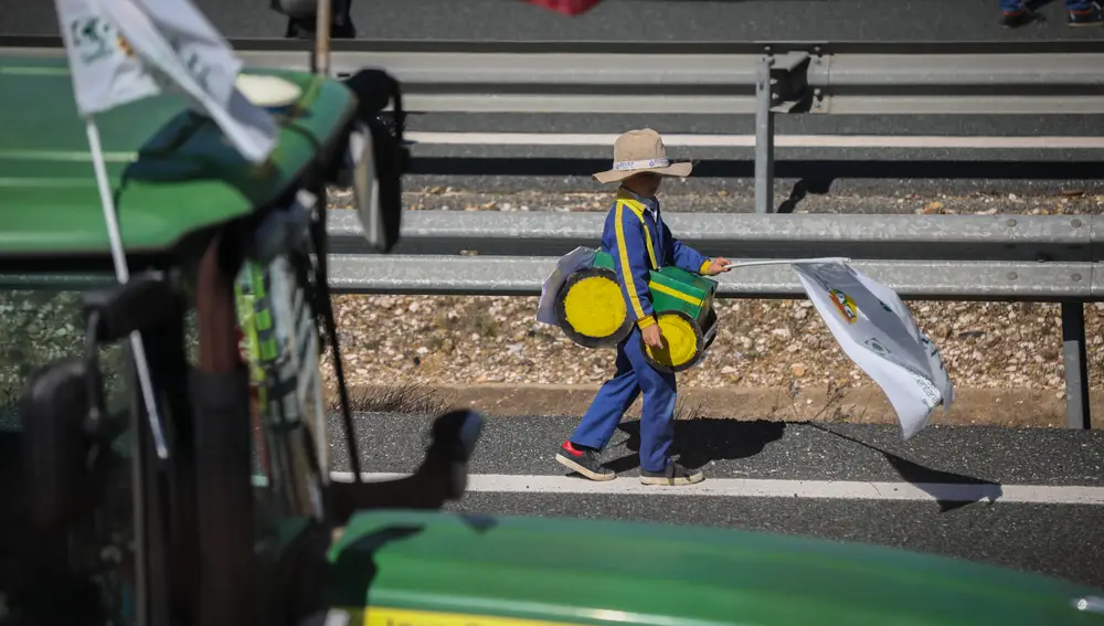 Un niño con un disfraz de tractor durante la manifestación que ha cortado la A-4 en Carmona durante la tractorada organizada por agricultores en Sevilla