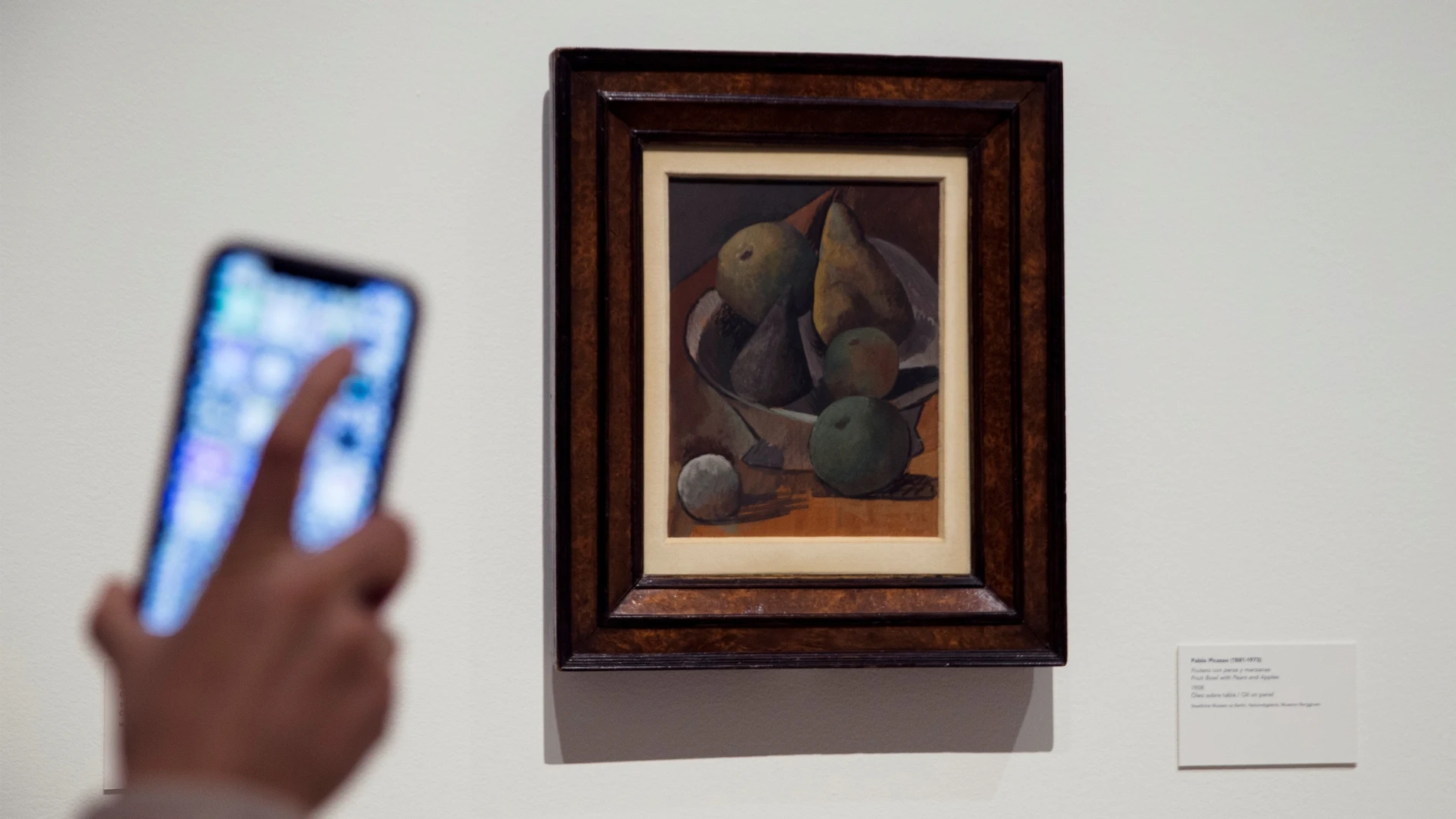 Una persona con el móvil delante de la obra "Frutero con Peras y Manzanas" 1908, de Pablo Picasso que forma parte de la nueva exposición temporal "Genealogías del arte, o la historia del arte como arte visual"