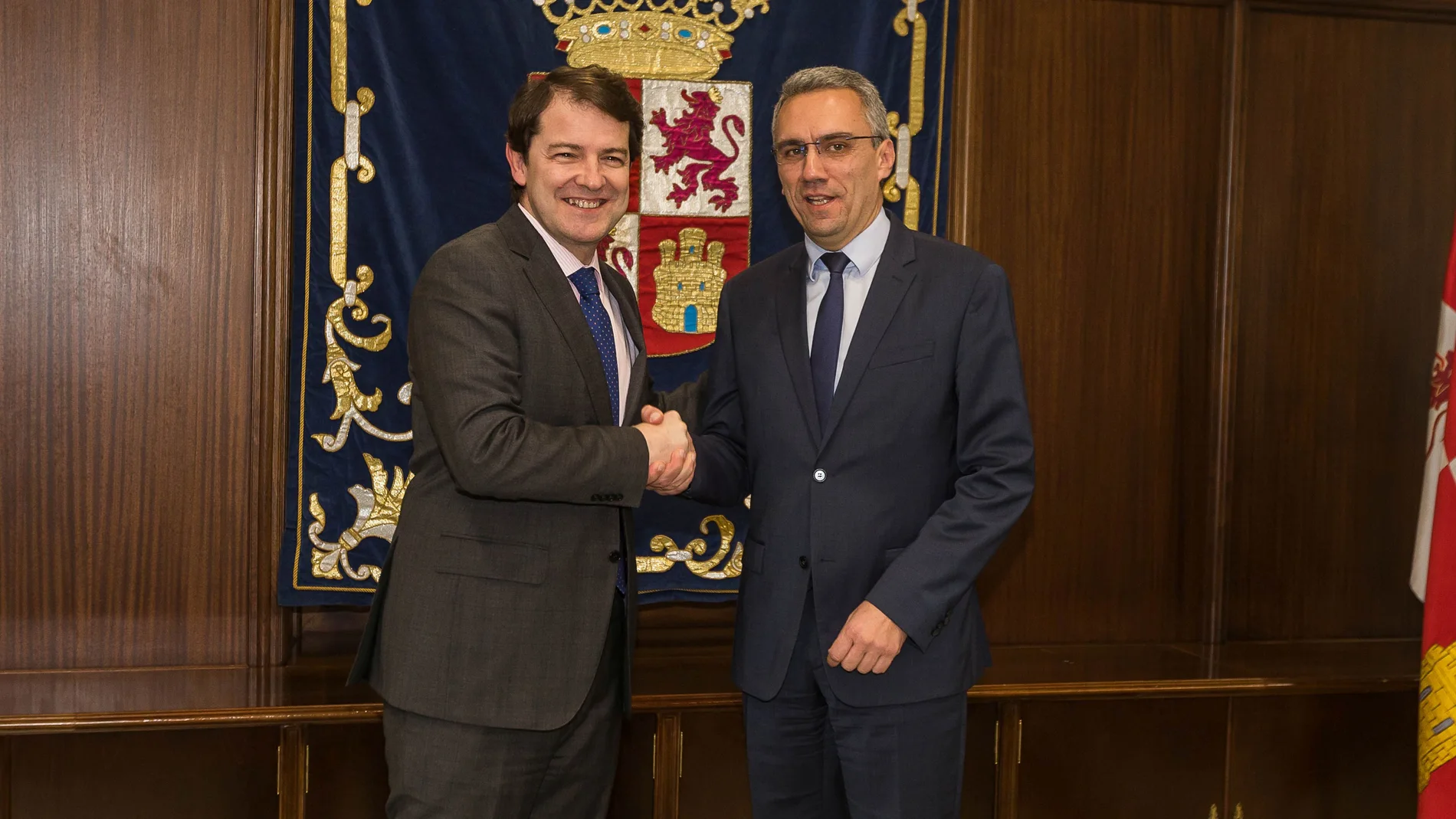 El presidente de Castilla y León, Alfonso Fernández Mañueco; estrecha la mano al delegado del Gobierno de España, Javier Izquierdo, en el primer encuentro institucional entre ambos dirigentes