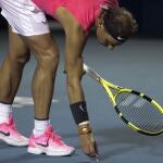 Rafa recoge un objeto de la pista en su partido ante Kecmanovic