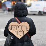 Uma mujer luce un cartel en el que se puede leer, en francés, "Respetame"