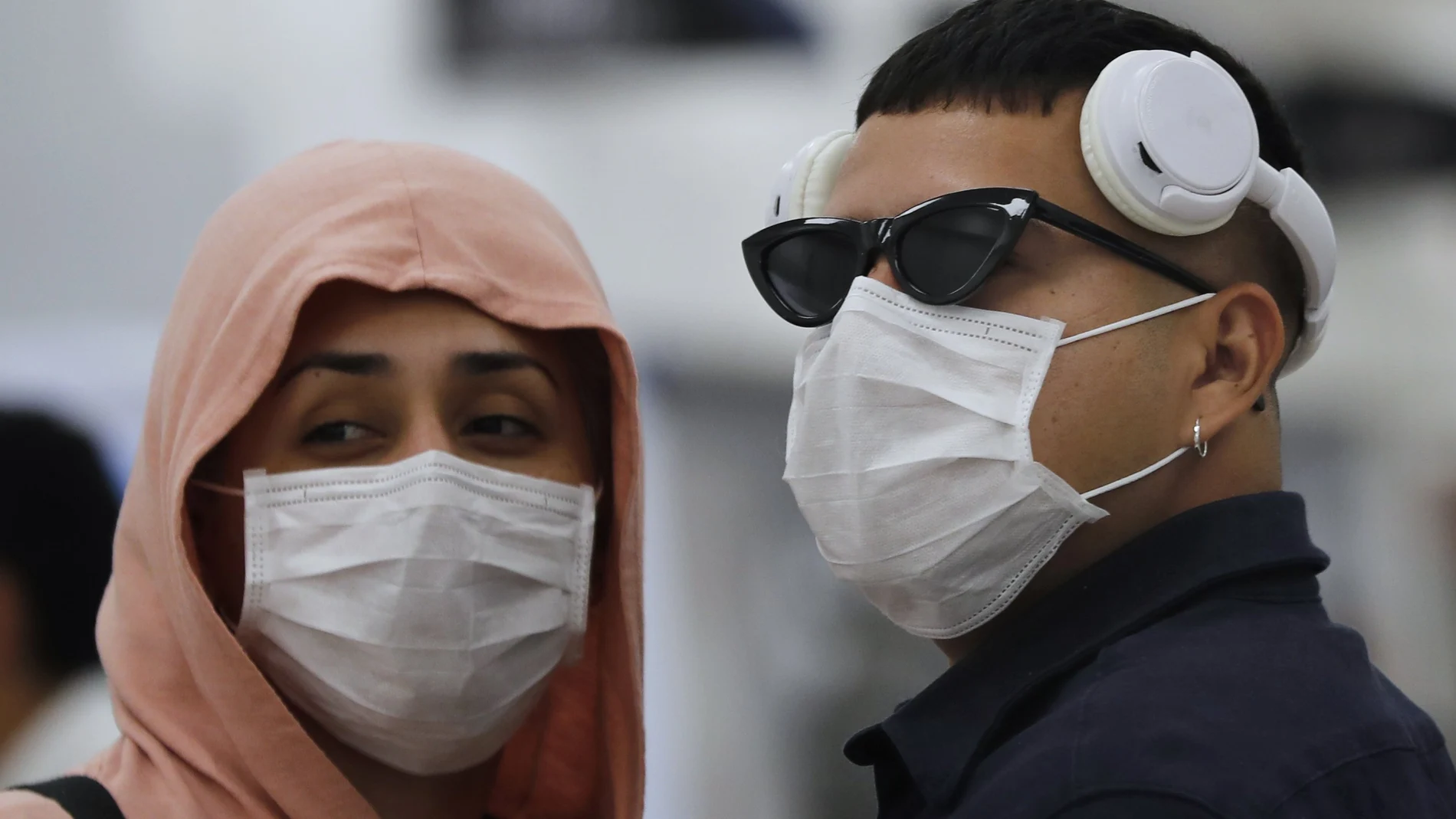 Una pareja con mascarillas en el aeropuerto México (AP Photo/Marco Ugarte)