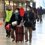 Dos turistas asiáticos protegidos con mascarillas recorren las Galerías de Vittorio Emanuele de Milán/EFE