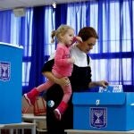 Una mujer acude a votar junto a su hija en un colegio electoral en Tel Aviv