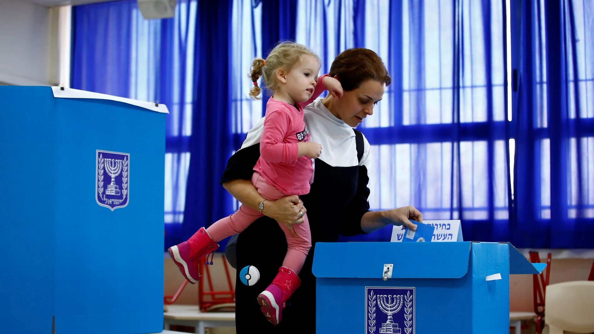 A woman casts her ballot as she votes in Israel's national election at a polling station in Tel Aviv, Israel
