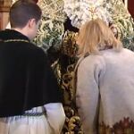 Una mujer rinde culto a una virgen a través del acto del besamanos