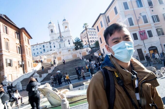 Un turista pasea con mascarilla por la Plaza de España en Roma (Italia), este miércoles